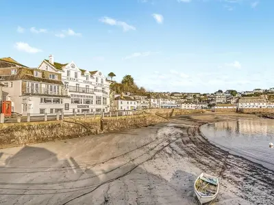 a boat sitting on the sand on a beach at Bessborough in Saint Mawes