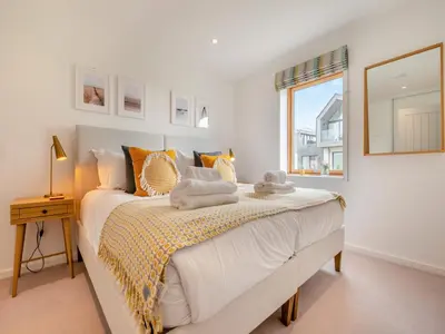 a bedroom with a large bed with a window at 3 Karn Havos in Mawgan Porth