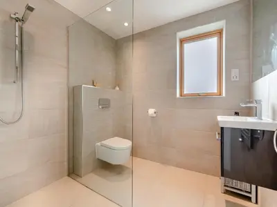 a bathroom with a shower and a toilet and a sink at 3 Karn Havos in Mawgan Porth