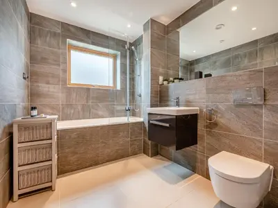 a bathroom with a toilet and a tub and a sink at 3 Karn Havos in Mawgan Porth