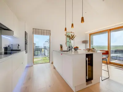 a kitchen with white cabinets and a large window at 3 Karn Havos in Mawgan Porth