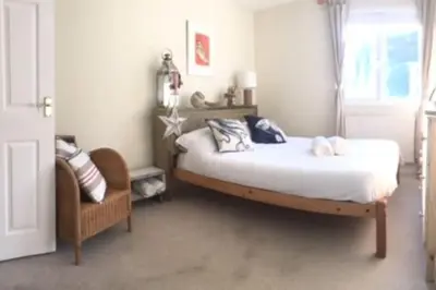a bedroom with a bed and a chair at Fabulous Beach Pad Just 20 Paces From The Sea in Mawgan Porth