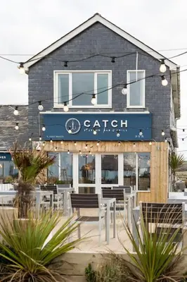 a restaurant with chairs in front of a building at Fabulous Beach Pad Just 20 Paces From The Sea in Mawgan Porth