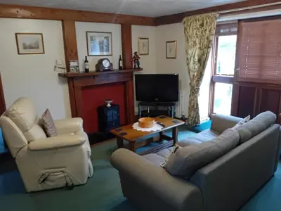 a living room with a couch and chairs and a tv at Robins Nest in Liskeard