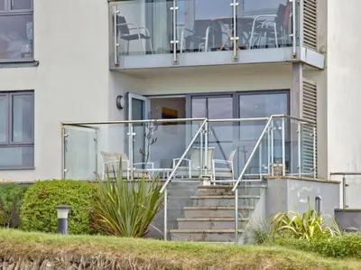 a house with stairs and chairs on a balcony at 15 Ocean Gate Newquay in Crantock