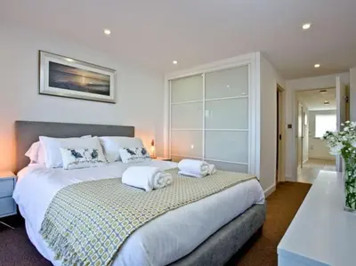 a bedroom with a large bed with towels on it at 15 Ocean Gate Newquay in Crantock