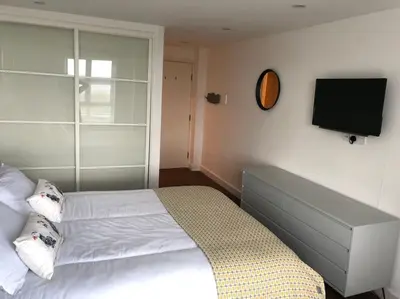 a bedroom with a bed and a flat screen tv at 15 Ocean Gate Newquay in Crantock