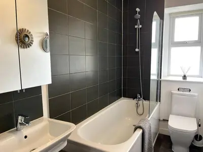 a bathroom with a tub and a toilet and a sink at Flat in the heart of Newquay in Newquay
