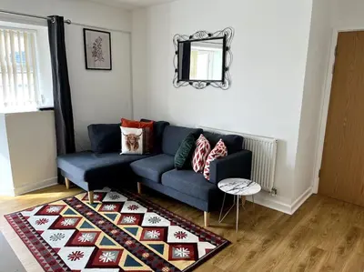 a living room with a blue couch and a rug at Flat in the heart of Newquay in Newquay