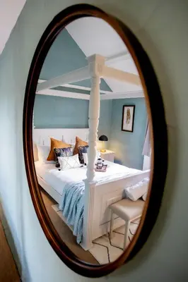 a bedroom with a white bed and a mirror at Treworgie Barton Cottages - Chappell in Bude