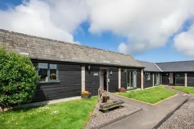 a brick house with a yard at Treworgie Barton Cottages - Chappell in Bude