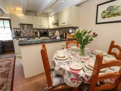 a kitchen with a table and chairs with a table and a tableclotholitics at Swallow Cottage in Helston