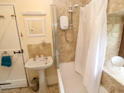 a bathroom with a sink and a shower at Swallow Cottage in Helston