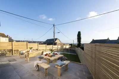 a patio with a table and chairs on a roof at Atlantic Point, Porthleven - Free WiFi & Parking - Coffee Machine - Close to Harbour & Town in Porthleven