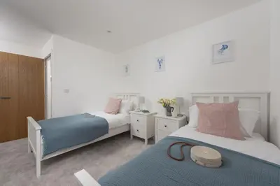 a bedroom with two beds and a blue blanket at Atlantic Point, Porthleven - Free WiFi & Parking - Coffee Machine - Close to Harbour & Town in Porthleven