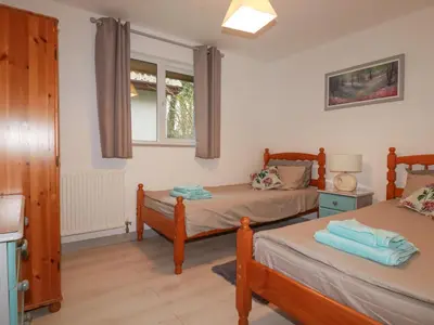 a bedroom with two beds and a window at Rainbow Lodge in Bodmin