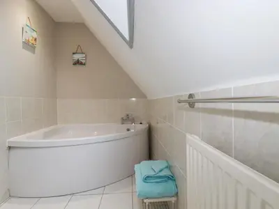 a bathroom with a white tub and a sink at Rainbow Lodge in Bodmin