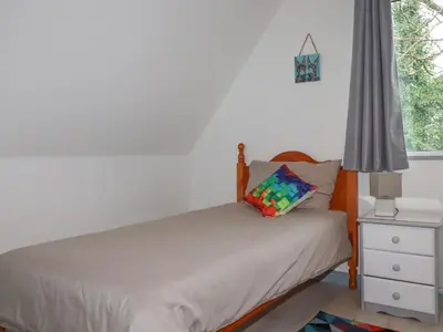 a small bedroom with a bed and a window at Rainbow Lodge in Bodmin