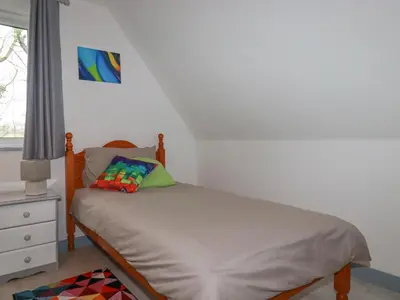 a small bedroom with a bed and a window at Rainbow Lodge in Bodmin