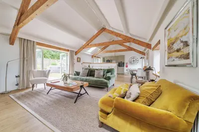 a living room with a yellow couch and a table at The Granary in Camelford