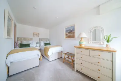 a bedroom with two beds and a dresser at The Granary in Camelford
