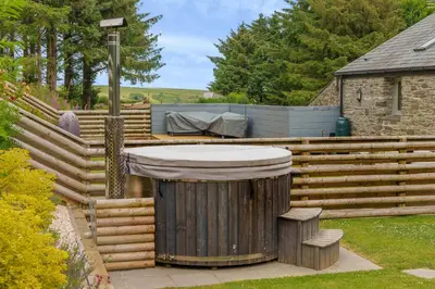 a wooden fence with a hot tub in a yard at The Granary in Camelford