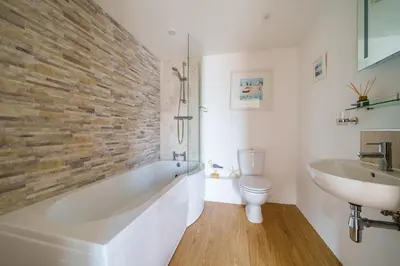 a bathroom with a tub and a sink and a toilet at The Granary in Camelford
