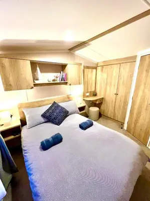 a bedroom with two beds with blue pillows on them at The Beach Retreat in Par