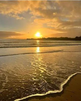 a sunset on a beach with the ocean at The Beach Retreat in Par