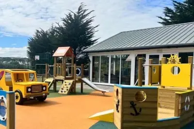 a playground with a slide and a play structure at The Beach Retreat in Par