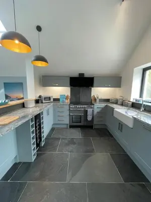 a large kitchen with white cabinets and appliances at Gulland 4 Bed Sleeps 8 with Hot tub in Treknow