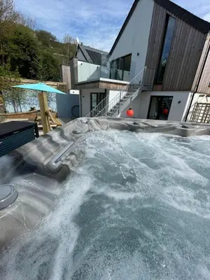 a swimming pool in front of a house at Gulland 4 Bed Sleeps 8 with Hot tub in Treknow