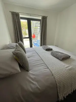 a bedroom with a large bed with pillows and a window at Gulland 4 Bed Sleeps 8 with Hot tub in Treknow