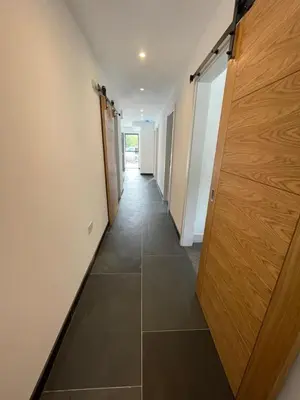 an empty hallway with a wooden door in a building at Gulland 4 Bed Sleeps 8 with Hot tub in Treknow