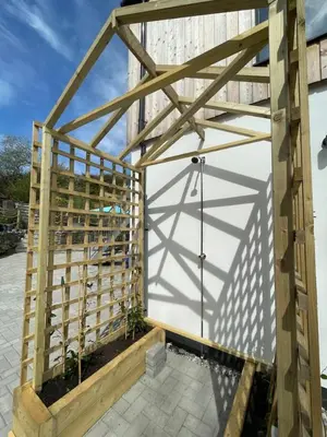 a wooden fence around a white garage door at Gulland 4 Bed Sleeps 8 with Hot tub in Treknow