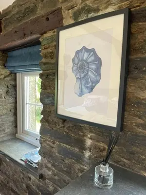a picture of a flower on a brick wall with a vase at The Hayloft - New Dog friendly with garden and parking in Port Isaac