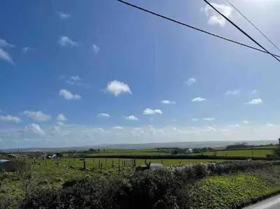 a view of a green field with a blue sky at The Hayloft - New Dog friendly with garden and parking in Port Isaac