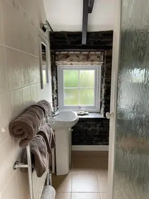 a bathroom with a sink and a window at The Hayloft - New Dog friendly with garden and parking in Port Isaac