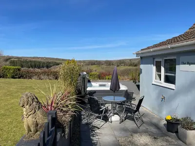 a patio with a table and chairs and a pool at The Retreat in Bodmin