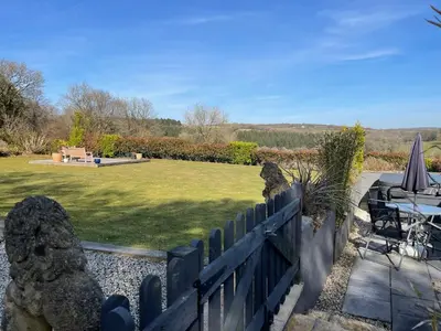 a garden with a fence and a table and a lawn at The Retreat in Bodmin