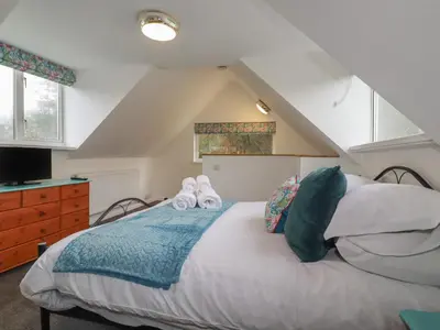 a bedroom with a bed with shoes on it at The Retreat in Bodmin