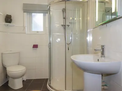 a bathroom with a shower and a toilet and a sink at The Retreat in Bodmin