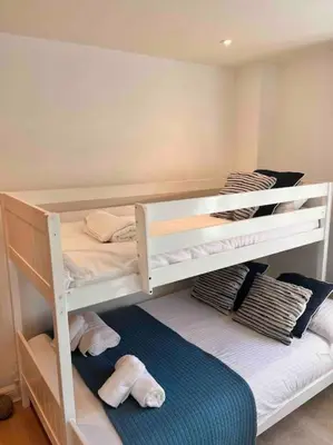 a bedroom with two bunk beds with towels at 2Bed with Pool & Sea View Apartment in Newquay