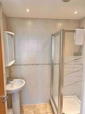 a bathroom with a shower and a sink at 2Bed with Pool & Sea View Apartment in Newquay