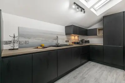 a kitchen with black cabinets and a view of the ocean at 2 Bed in St. Ives oc-r28154 in St Ives