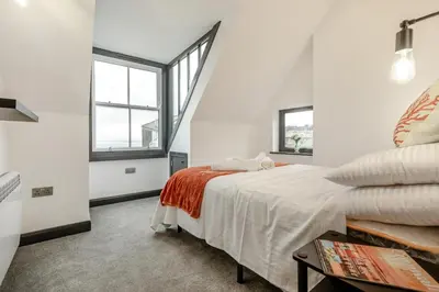 a white bedroom with a bed and two windows at 2 Bed in St. Ives oc-r28154 in St Ives