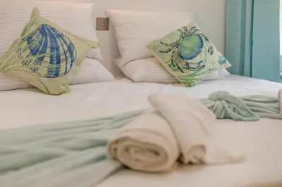a white towel laying on a bed with pillows at 2 Bed in St. Ives oc-s28155 in St Ives
