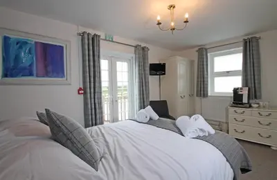 a bedroom with a large bed with towels on it at Halfway House Inn in Wadebridge