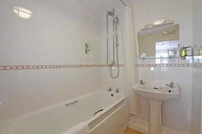 a bathroom with a tub and a sink and a bath tub at Halfway House Inn in Wadebridge