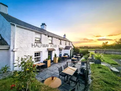 a hotel with tables and chairs in front of a building at Halfway House Inn in Wadebridge
